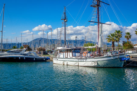 Corfu Island / Greece- May 5, 2019: View of beautiful Gouvia port marina - calm sea, white yachts and blue sky with white clouds, reflecting on water surface, and mountains on the horizon.のeditorial素材