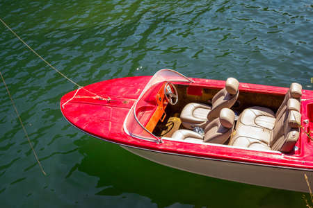 Part top view of old red motor boat with leather seats on a calm lake water surfaceの写真素材