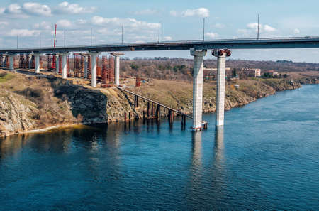 Construction of automobile bridge across the river. Industrial landscape.の写真素材