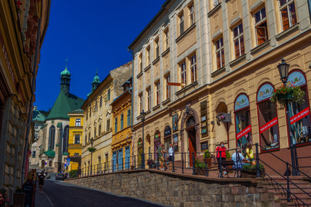 Banska Stiavnica, Slovakia - August 14, 2021: cityscape - street of beautiful historic town with medieval architecture - colorful house facades and church of Saint Catherine.のeditorial素材