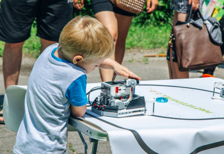 Zaporizhia, Ukraine- June 19, 2021: Charity Family festival: boy exploring robots at outdoors modern technologies exhibition.のeditorial素材