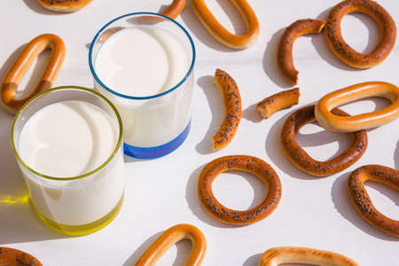 Fresh milk in glasses and bagels with poppy seeds on a table.の写真素材