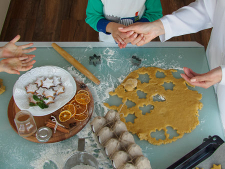 The process of making Christmas cookies for mom and children. Children cut cookies with metal molds....