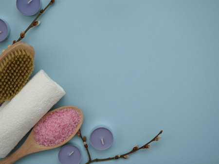 Flat lay set for spa treatments with copy space on blue background, top view. Body care and grooming concept. Dry brush massage for cellulite, sea salt scrubsの写真素材