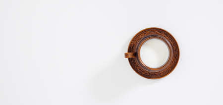 Farm organic milk in handmade clay cup with birch bark trim and clay saucer on white background with...