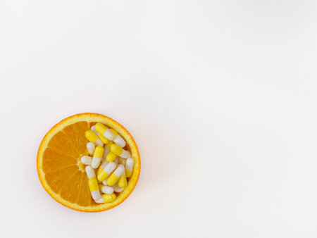 Vitamin C capsules and orange isolated on white background with copy space, flat lay, top view. Natural organic vitamins conceptの写真素材