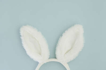 Easter bunny as a symbol of Easter. Minimalistic Easter composition with bunny ears on a pastel blue background. Copy space, top view, flat layの写真素材