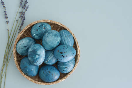 Trendy Easter background with Easter eggs in the color of the night blue sky and dried lavender branches on a gentle blue background with copy space, top view, flat lay. Easter is coming soon. Spring holiday easterの写真素材