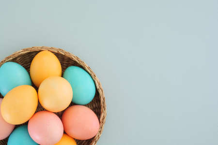 Minimalistic Easter background with delicate Easter eggs in pastel colors on a blue background. Easter composition. Easter tradition of painting eggs. Top view, flat lay, copy spaceの写真素材