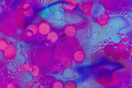 Abstract background. Orange with purple color. Distortions in water with drops of oil. Bright abstraction, ultraviolet. Circles on the waterの写真素材