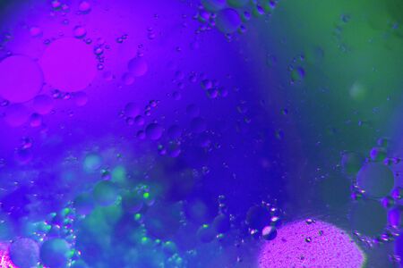 Abstract background. Orange with purple color. Distortions in water with drops of oil. Bright abstraction, ultraviolet. Circles on the waterの写真素材