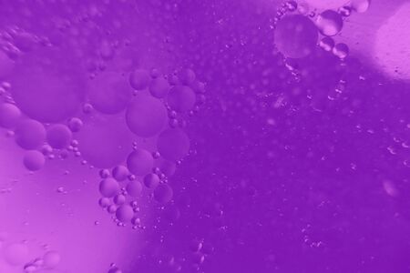 Abstract background. Orange with purple color. Distortions in water with drops of oil. Bright abstraction, ultraviolet. Circles on the waterの写真素材