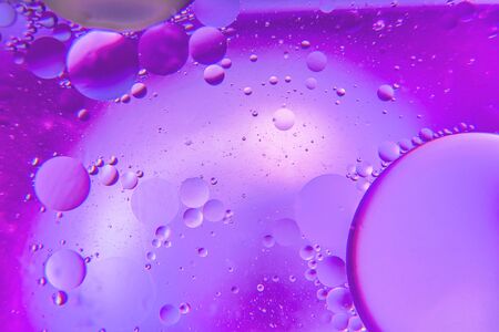 Abstract background with purple color. Distortions in water with drops of oil. Bright abstraction, ultraviolet. Circles on the waterの写真素材