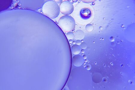 Abstract background with purple color. Distortions in water with drops of oil. Bright abstraction, ultraviolet. Circles on the waterの写真素材