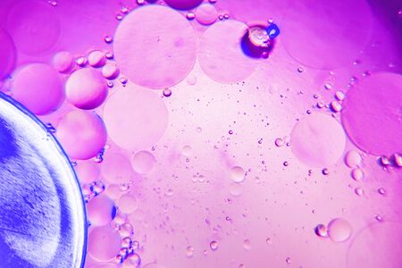 Abstract background with purple color. Distortions in water with drops of oil. Bright abstraction, ultraviolet. Circles on the waterの写真素材