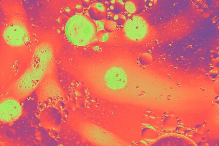 Abstract background with purple and pink bokeh lights color. Distortions in water with drops of oil. Bright abstraction, ultraviolet. Circles on the waterの写真素材