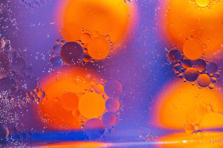 Abstract background. Orange with purple color. Distortions in water with drops of oil. Bright abstraction, ultraviolet. Circles on the waterの写真素材