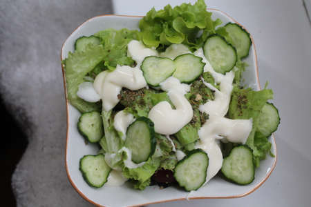 crust summer vegetarian salad from green cucumber and leaves of herbsの写真素材