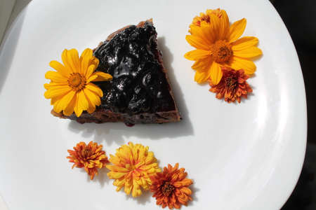 appetizing vegetarian chocolate  piece of cake decorated with orange  flowersの写真素材