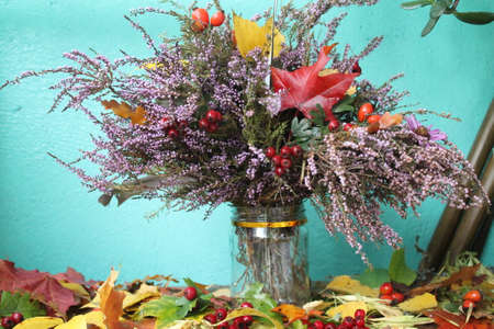 pompous autumn bouquet from bloom bright violet heather decorated with red ripe berries of dog-rose and hawthorn, leaves of maple and oakの写真素材