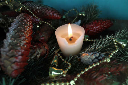 bright burn candle, golden chaplet, red cones fir-tree decoration for Christmas and New Year holidaysの写真素材