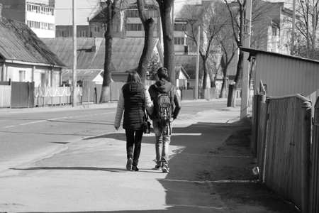 pair of young boy and girl fall in love walk on street in spring day