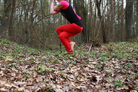 young beautiful woman made yoga asana twisted legs and hands ( Garudasana) in spring morning forest
