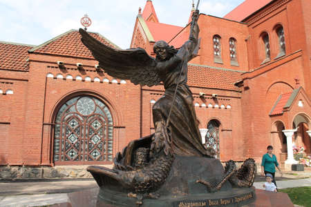 bronze statue of Saint Archangel Michel kill snack stay  near catholic church " Simona and Elena" on square, Minsk, May, 2015, Belarusの写真素材