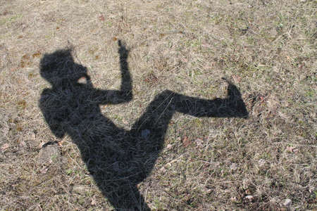 dancing in  battle shadow of human perfomance on the grassの写真素材