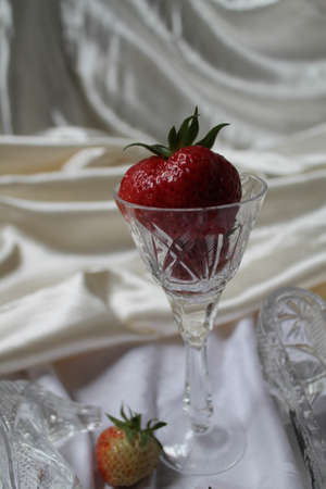 red juicy appetizing big strawberry in crystal glass sweet dessertの写真素材
