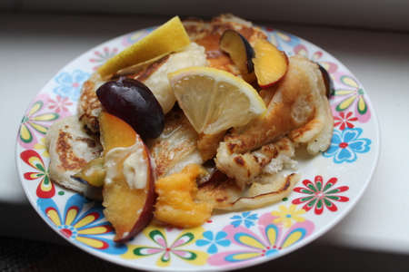 appetizing golden vegetarian pancakes with pulms and lemon with honey on breakfastの写真素材