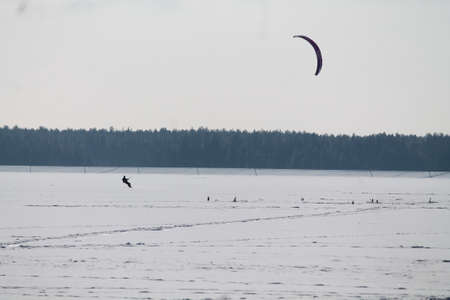brave man under parachute on the snowboard on frozen sea in sunny dayの写真素材