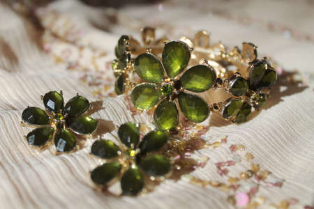 beautiful jewelry set from earrings and bracelet in shape of green shine flowerの写真素材