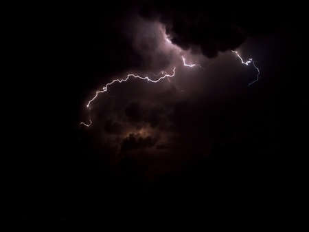 Lightning in dark and cloudy sky with purple colorshades