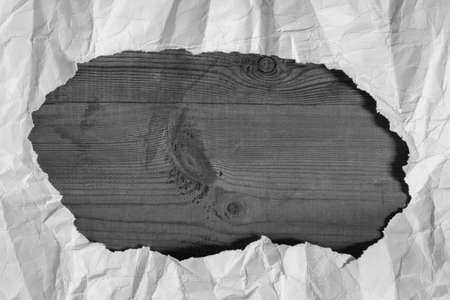 Creased White Paper Torn Hole Located On Empty Brown Wooden Board With Copyspace. Grey And White Colors.の写真素材