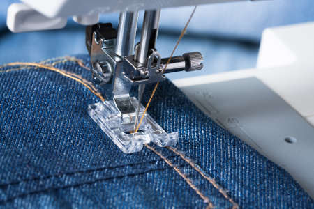 Jeans. Foot Of Sewing Machine On Jeans Fabric.の写真素材