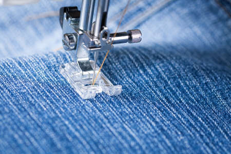 Jeans. Foot Of Sewing Machine On Jeans Fabric.の写真素材