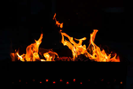 Burning Wood Bonfire In Brazier On Black Dark Background Outdoor.