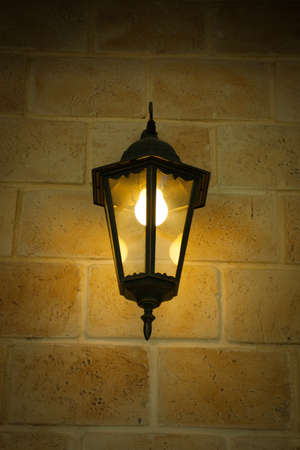 Old Iron Street light Lantern On Beige Brick Wall In Retro Style.