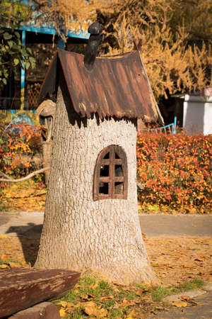 Toy Wooden House. Cute Decorative House From Tree Stump In Sunny Colorful Autumn Park.の写真素材