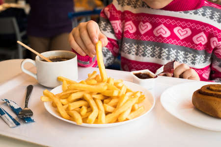 Little Girl Eats Sweet Potato Fries With Ketchup In Cafe In Moscow. On White Tray Tea, Potato Fries,...