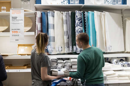 Moscow, Russia - February 10, 2018: Woman And Man Choose Liked Tablecloth For Dining Table In IKEA Close Up.のeditorial素材