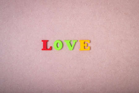 Inscription Love On Brown Wooden Board Background Top View.の写真素材