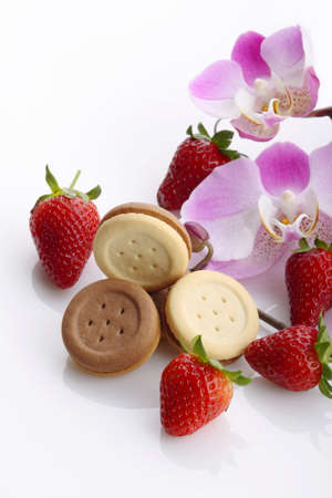 Biscuits, strawberries and flowers of orchidの写真素材