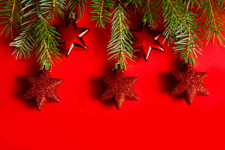 Christmas background concept. fir branches and Christmas decorations, toys, red stars on a red...