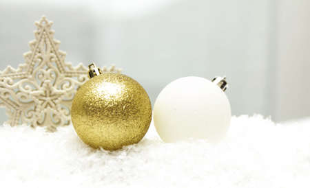 Christmas white and gold Christmas balls in white snow in the background is a carved star-shaped...