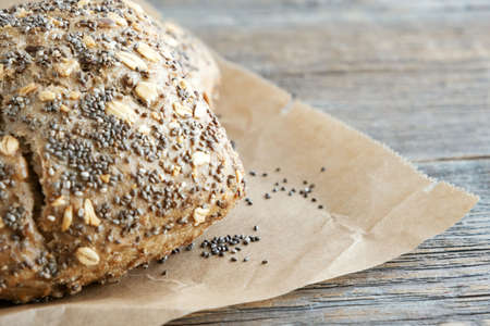 Whole grain, rye buns with sunflower seeds, chia and oatmeal flakes on baking paper. Close-up. Place for text.の写真素材