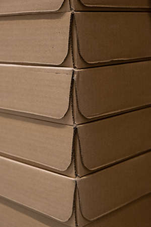 Close-up corners of cardboard boxes. A stack of packaging cardboard. Food delivery in cardboard boxes. Vertical orientation. Background, Textureの写真素材