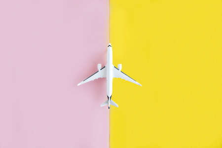 Model of a white plane on a yellow and pink background. Travel, flight concept. Place for text....