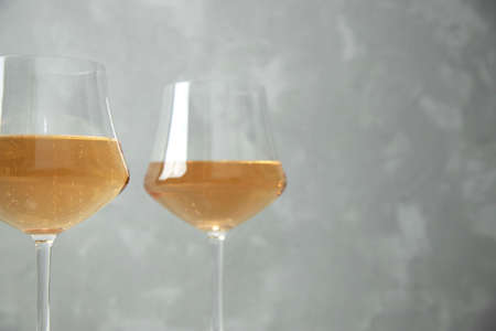 Two glass glasses with orange wine. Close-up. One glass is out of focus. Gray background.の写真素材